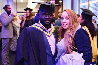 An image of Forster Amo in graduation robes at the MOL graduation.